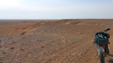 Je suis sur un petit plateau et la piste zigzag sur les collines avant de redescendre dans la plaine désertique.