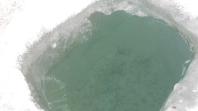 Un trou où les gens viennent chercher de l'eau, la photo ne rend pas bien mais on voit les cailloux au fond et il y a presque un mètre de glace.